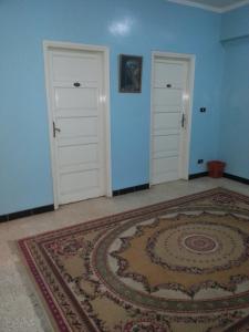 una habitación vacía con dos puertas y una alfombra en Fontana Luxor Hostel en Luxor