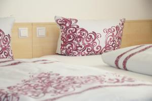 ein Bett mit roten und weißen Kissen darauf in der Unterkunft Gästehaus Adler in Biberach an der Riß