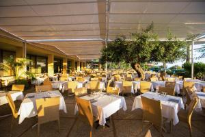 restauracja z białymi stołami i żółtymi krzesłami w obiekcie MClub Lipari w mieście Sciacca