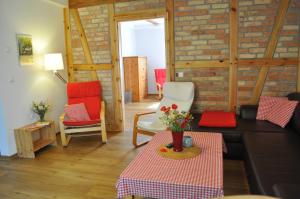 a living room with red chairs and a brick wall at Kulturfreizeiten Ferienwohnungen in Neuruppin