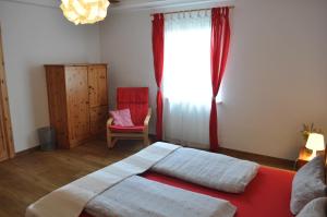 a bedroom with a bed and a window and a chair at Kulturfreizeiten Ferienwohnungen in Neuruppin