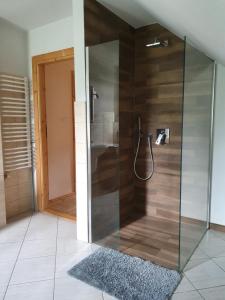 a shower with a glass door in a bathroom at Gosidomek in Zawoja