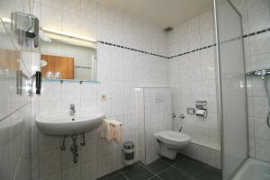 a bathroom with a sink and a toilet and a shower at Landgasthof Auerschmiede in Irschenberg +18 photos
