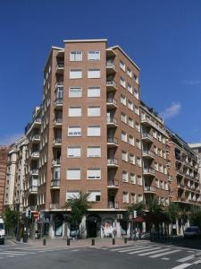 a large brick building on a city street at Apartamento con vistas al Estadio San Mamés in Bilbao