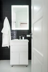 a white bathroom with a sink and a mirror at Status Apartments in Kyiv