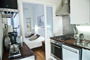 a kitchen with a stove top oven next to a bedroom at Helsinki Apartments in Helsinki