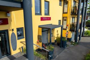 un edificio amarillo con un cartel en el costado en Seaside-Strandhotel en Timmendorfer Strand