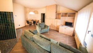Appartamenti Pirovano Bormio في بورميو: غرفة معيشة مع أريكة وغرفة طعام