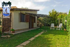 ein Haus mit einem Garten, einem Tisch und Stühlen in der Unterkunft Alle Riserve Vendicari in Casa Maccari