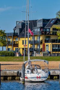 un velero atracado en el agua frente a un edificio en Seaside-Strandhotel en Timmendorfer Strand