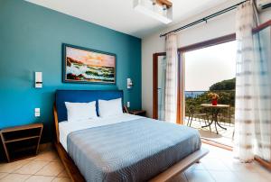 a blue bedroom with a bed and a balcony at Petrino Apartments in Parga