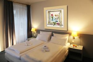 Postel nebo postele na pokoji v ubytování Altstadthotel Augsburg