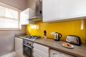 a kitchen with a stove and a plate of bread at homely - Central London King’s Cross Apartments in London