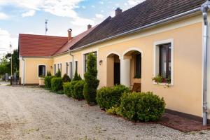 una casa con una fila de setos delante de ella en Kápolna Vendégház, en Kerkáskápolna