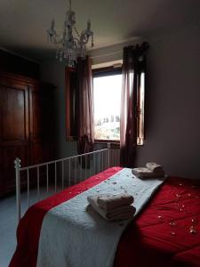een slaapkamer met een bed met rode lakens en een raam bij Il glicine in Siena