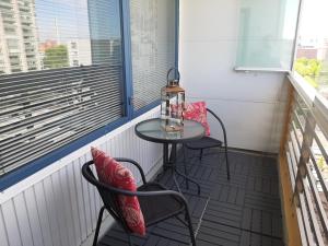 a small table and two chairs on a balcony at Seaside Downtown Apartment in Helsinki