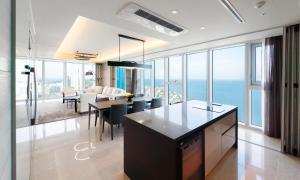 a kitchen and dining room with a view of the ocean at Grand Lct Residence in Busan