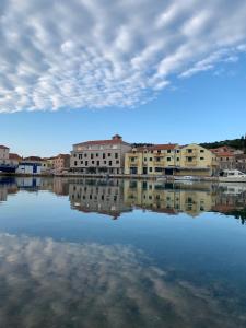 a reflection of buildings in a body of water at Apartmani Tisno TM in Tisno