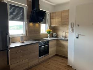 a kitchen with wooden cabinets and a sink and a window at Apartmani Tisno TM in Tisno +18 photos