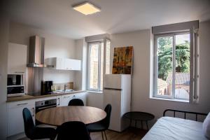 a small kitchen with a table and a table and chairs at ALBIAPPPART CENTRE in Albi