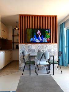 ein Esszimmer mit einem Tisch und Stühlen sowie einem TV in der Unterkunft Anja & Ogo Apartment sea View & Pool in Petrovac na Moru