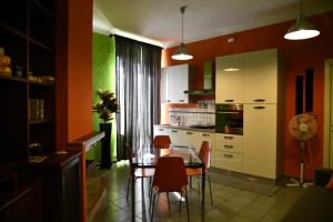 una cucina con tavolo in vetro e sedie di Appartamento Magia d'Estate a Sulmona