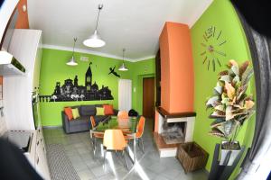 un soggiorno con pareti verdi, tavolo e divano di Appartamento Magia d'Estate a Sulmona