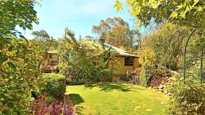 a garden with a house and a yard withgrass at Treetops Escape Albury in Albury