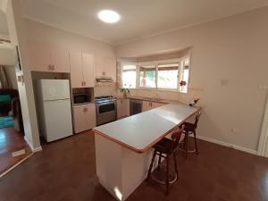 a kitchen with a white counter top and a refrigerator at Treetops Escape Albury in Albury