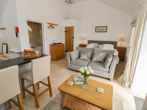 a living room with a couch and a table at Oak Barn in Daventry