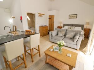 eine Küche und ein Wohnzimmer mit einem Sofa und einem Tisch in der Unterkunft Oak Barn in Daventry