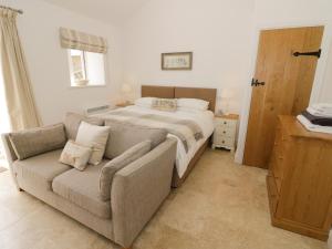 a bedroom with a bed and a couch next to a bed at Ash Barn in Daventry