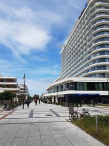 a large building with people walking in front of it at Apartament Cesarski Agnes- bezpłatny parking- Resort Cesarskie Ogrody in Świnoujście