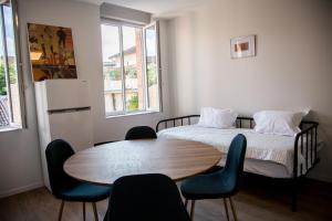 a room with a bed and a table and chairs at ALBIAPPPART CENTRE in Albi