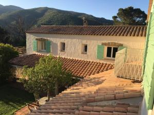 uma casa com persianas verdes e um telhado em Villa Bonheur Vallespir em Céret