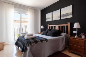 een slaapkamer met een bed met kussens erop bij Casa Jaime in Vejer de la Frontera +40 foto's