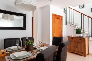 een eetkamer met een tafel, stoelen en een spiegel bij Casa Jaime in Vejer de la Frontera