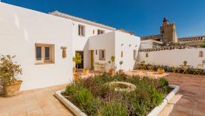 een wit huis met een binnenplaats met planten bij Romantic Ronda garden cottage in Ronda