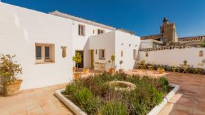 a white house with a courtyard with plants at Romantic Ronda garden cottage in Ronda