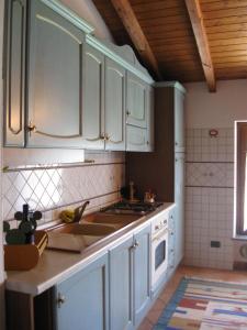 a kitchen with white cabinets and a sink at Residence La Bellotta in Oleggio