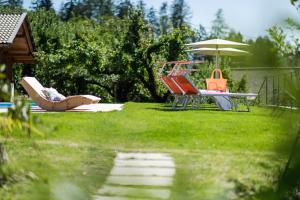 シェーナにあるHotel Alpenroseの庭の椅子・傘