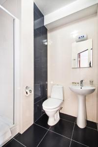 ein Bad mit einem WC und einem Waschbecken in der Unterkunft Status Apartments in Kiew