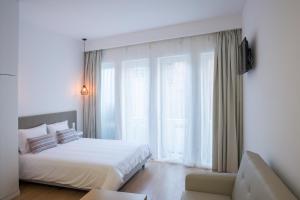 - une chambre blanche avec un lit et un canapé dans l'établissement Porto Bonjardim Apartments, à Porto