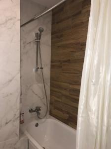 y baño con bañera y cortina de ducha. en Apartments on Perspektivnaya, en Kropyvnytskyi