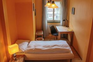 a small room with a bed and a desk at Gasthof Bären Aarburg last Check in 2100 pm in Aarburg