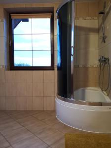 ein Bad mit einer Badewanne und einem Fenster in der Unterkunft Willa Borynówka in Kazimierz Dolny