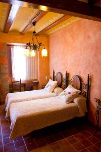 a bedroom with two beds and a window at A la Sombra de la Torre in Serra