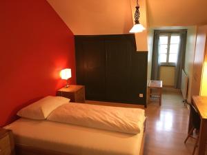 a bedroom with a bed and a red wall at Gasthof Bären Aarburg last Check in 2100 pm in Aarburg