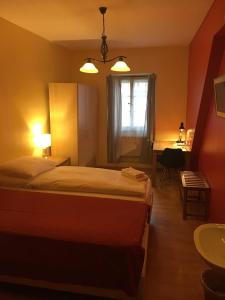 a bedroom with a bed and a bathroom with a sink at Gasthof Bären Aarburg last Check in 2100 pm in Aarburg
