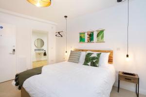 a bedroom with a large white bed and a table at Hues - Castle Cary in Castle Cary